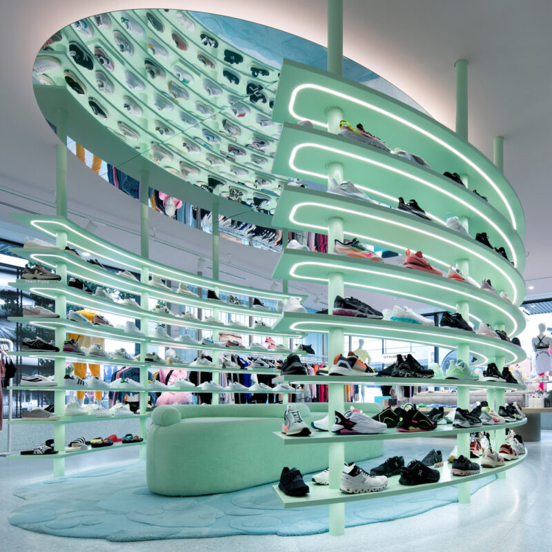 Contemporary retail space featuring LPA Lighting’s dynamic LED installation, with soft mint illumination accentuating curved shelving and enhancing product visibility and ambience.